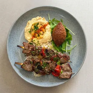 Grilled beef skewers with rice and sides