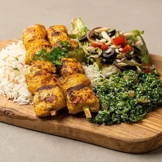 Grilled chicken skewers with rice and sides